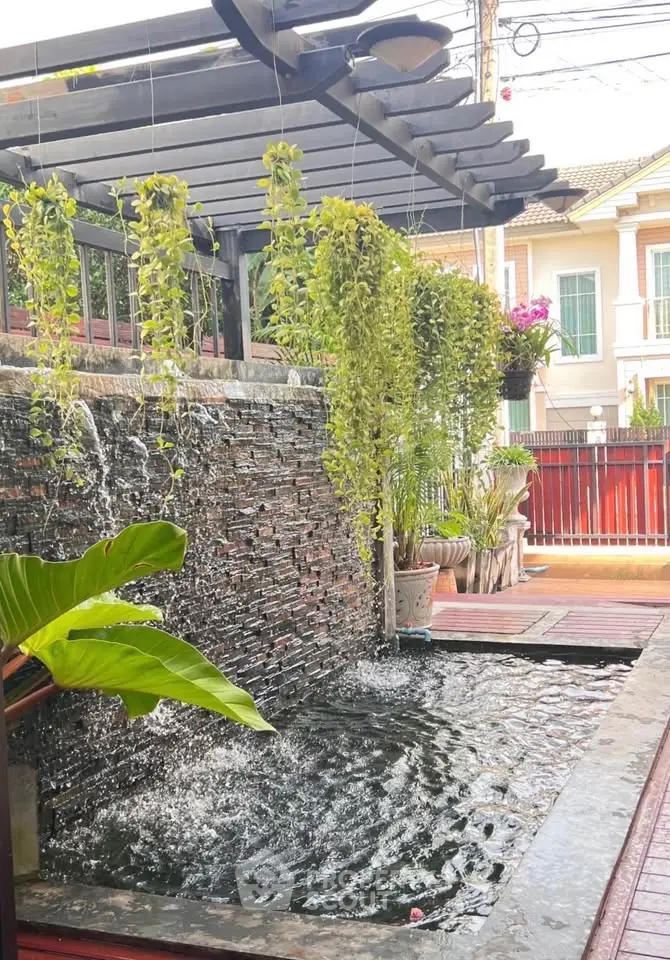 Charming garden with water feature and lush greenery in a residential setting.