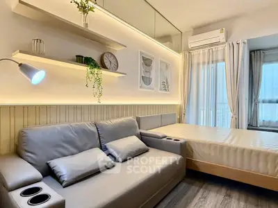 Modern studio apartment with cozy living area and bed, featuring stylish decor and natural light.