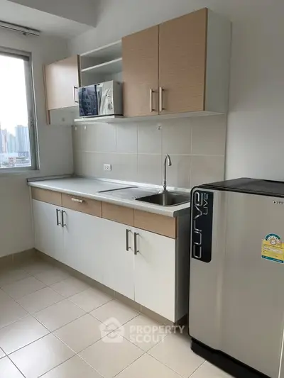 Modern kitchen with sleek cabinetry and city view window