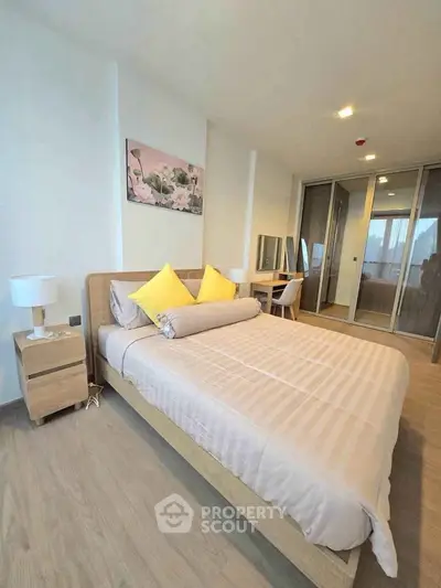 Modern bedroom with cozy decor and ample natural light, featuring a stylish bed and elegant furnishings.
