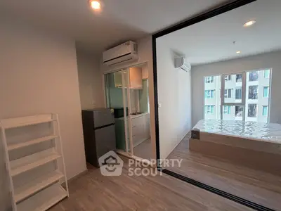 Modern studio apartment with sleek design and large windows for natural light.