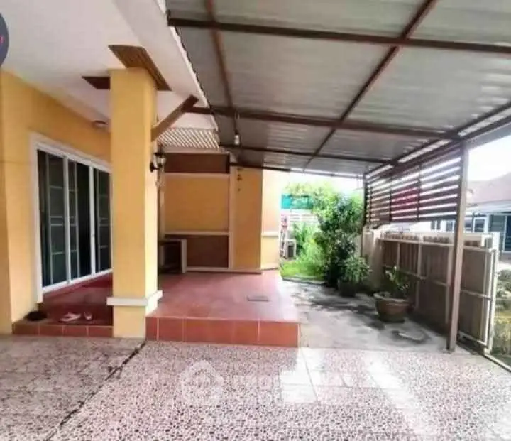Spacious covered patio area with tiled flooring and garden view in suburban home.