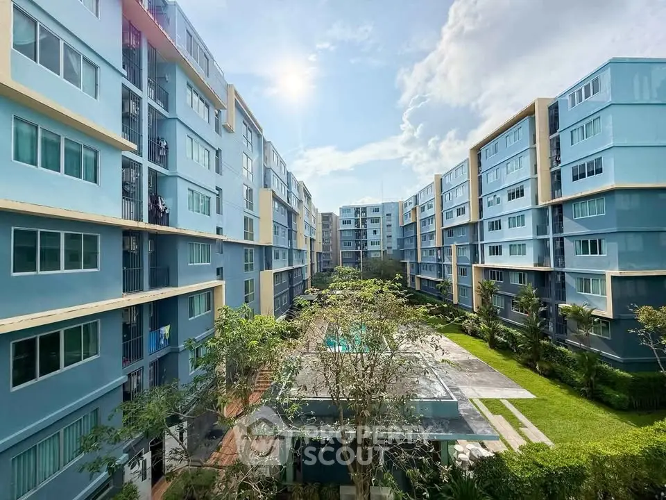 Modern apartment complex with lush garden and pool, offering serene living environment.
