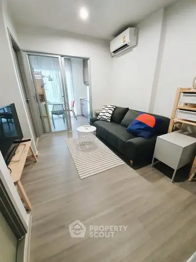 Modern living room with sleek design and air conditioning, featuring a cozy sofa and stylish decor.