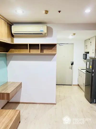 Modern apartment interior with built-in shelves and compact kitchen