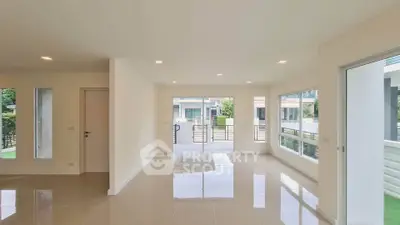 Spacious modern living room with large windows and glossy tiled floors