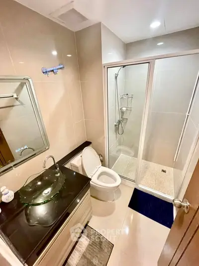 Modern bathroom with glass shower, sleek vanity, and contemporary fixtures.