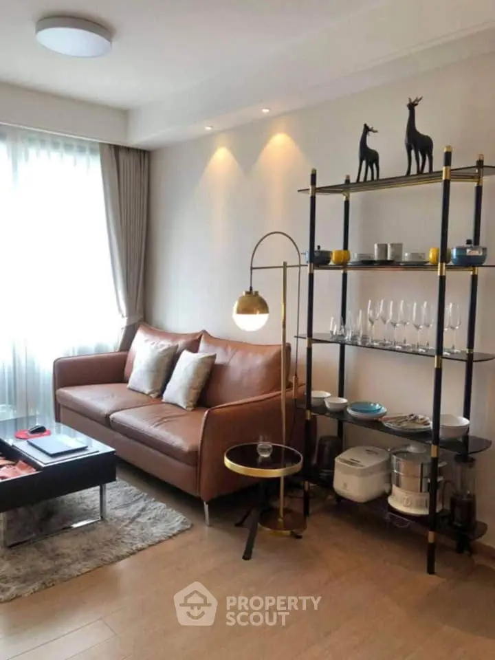 Stylish living room with modern decor, leather sofa, and elegant shelving unit in a cozy apartment.