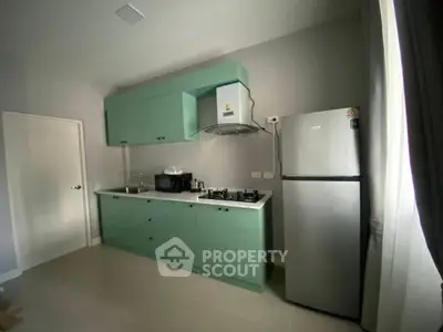Modern kitchen with mint green cabinets and stainless steel appliances