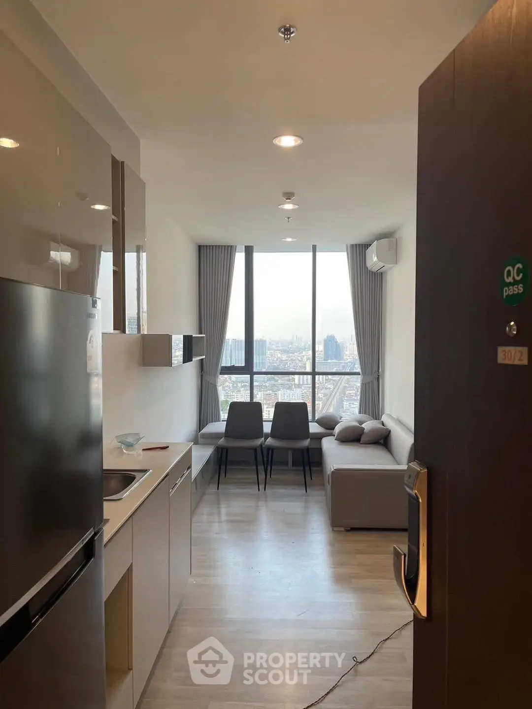 Modern apartment with open kitchen and stunning city view from living room.