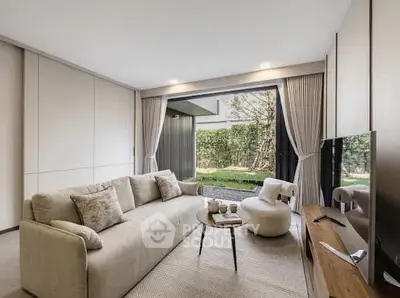 Modern living room with elegant decor and garden view, featuring cozy seating and stylish furniture.