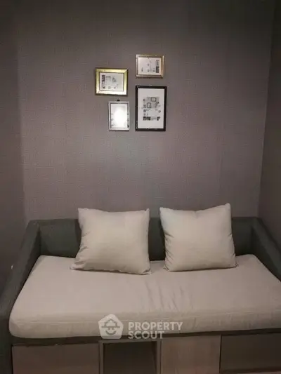 Cozy small living room with a modern sofa and framed wall art, perfect for compact spaces.