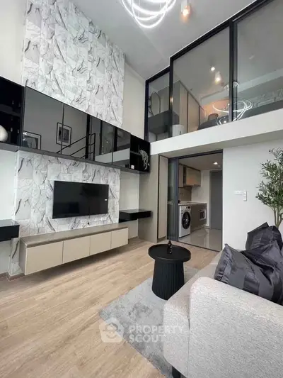 Modern loft apartment with stylish living room and mezzanine, featuring marble wall and sleek furnishings.