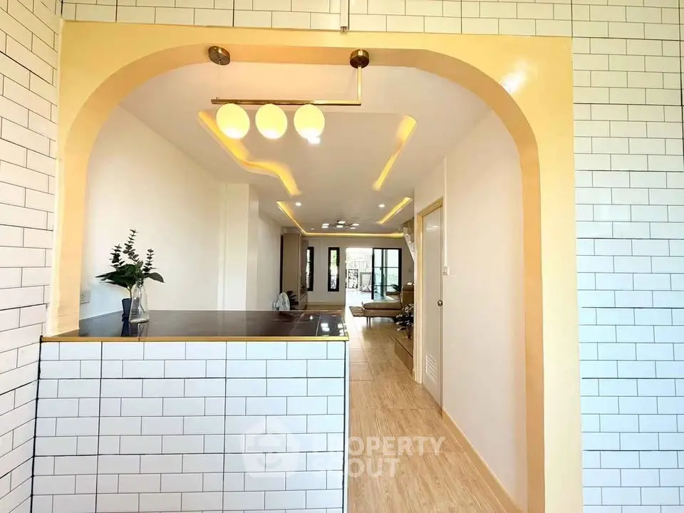 Modern open-layout kitchen with stylish lighting and white subway tiles.
