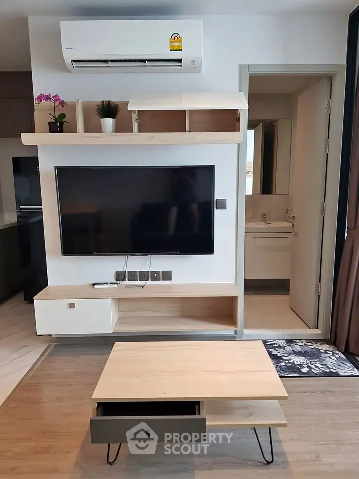 Modern living room with wall-mounted TV and sleek wooden furniture