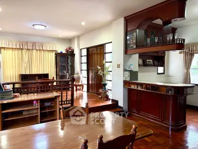 Spacious living and dining area with elegant wooden furniture and natural light.
