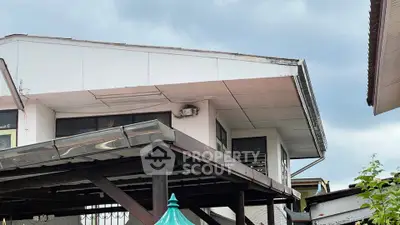 Unique elevated house exterior with modern design and overcast sky backdrop.
