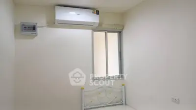 Minimalist bedroom with air conditioning and window, perfect for cozy living.