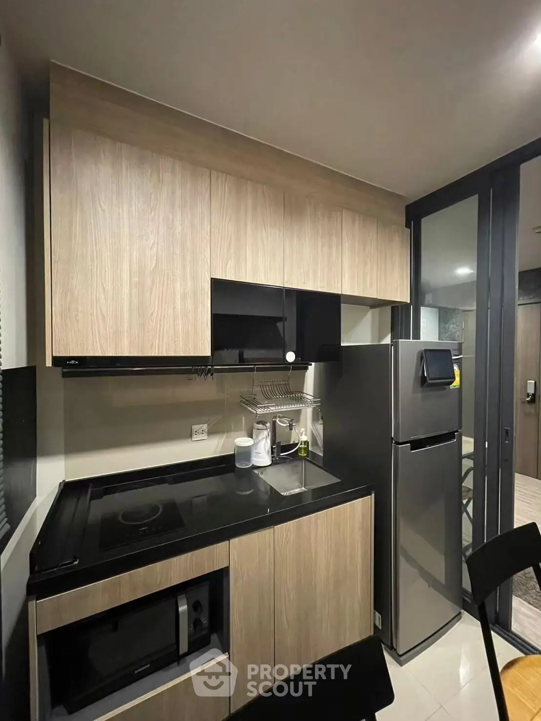 Modern kitchen with sleek cabinetry and stainless steel appliances in a stylish apartment.