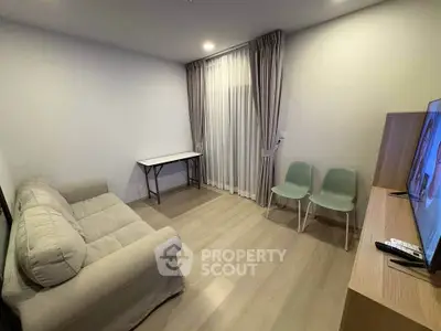 Cozy living room with modern decor, featuring a comfortable sofa, sleek chairs, and a flat-screen TV.
