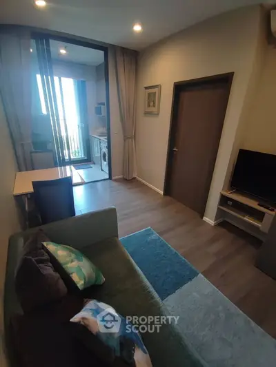 Modern living room with balcony and washing machine, featuring stylish decor and open layout.