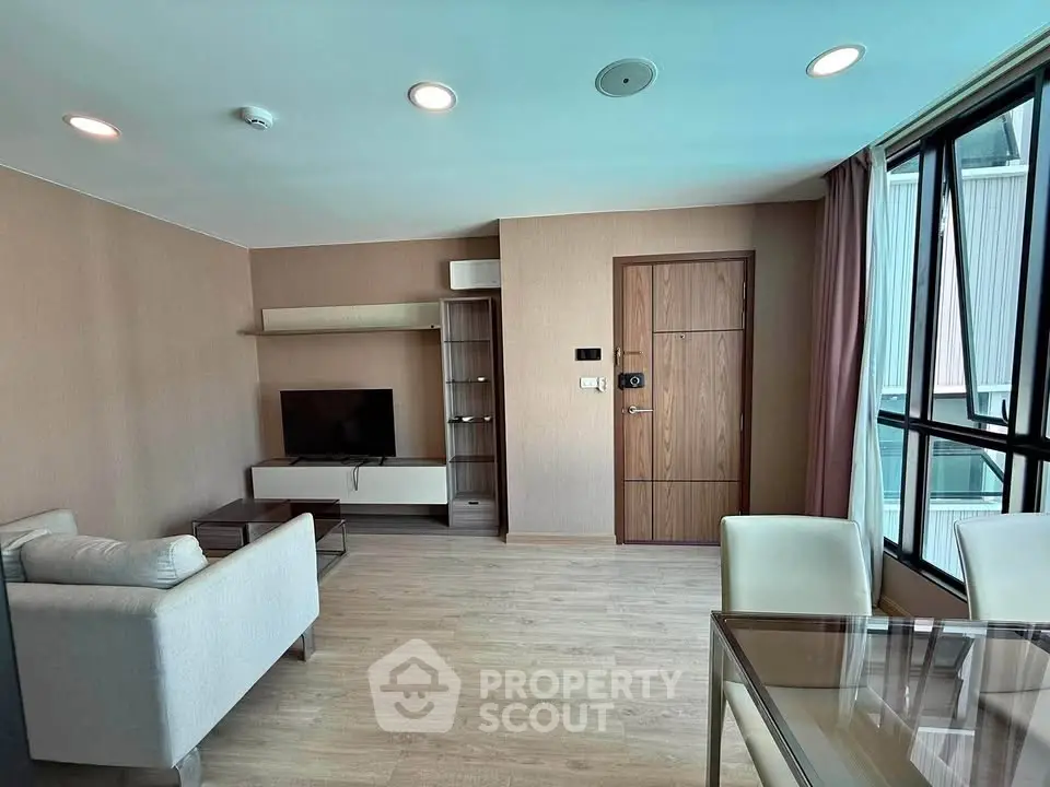 Modern living room with sleek furniture and large windows in a stylish apartment.