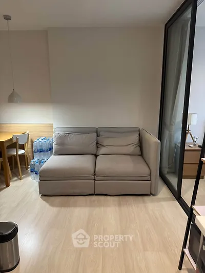 Cozy living room with modern sofa and dining area, perfect for relaxation and entertaining.