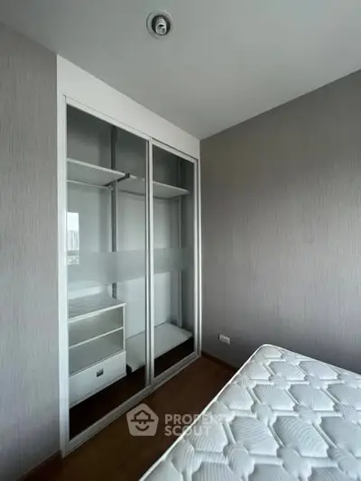 Modern bedroom with sleek wardrobe and comfortable mattress in a stylish apartment.