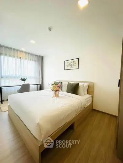 Modern bedroom with elegant decor and natural light, featuring a cozy bed and stylish furnishings.