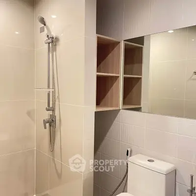 Modern bathroom with sleek shower and storage shelves, perfect for contemporary living.