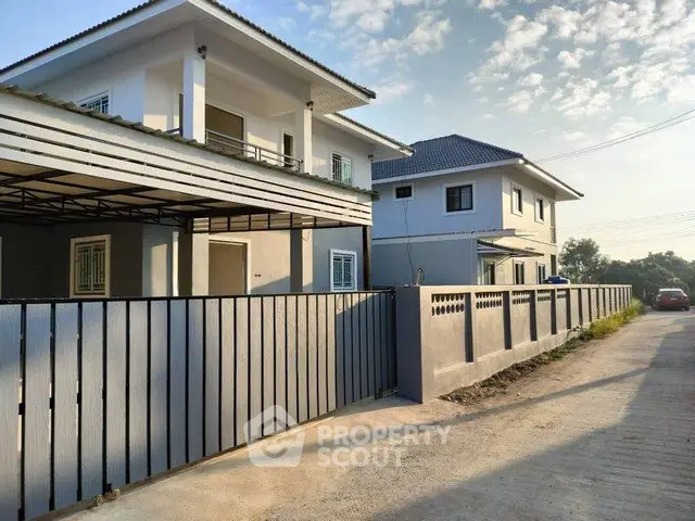 Modern two-story house with sleek design and spacious driveway in a serene neighborhood.