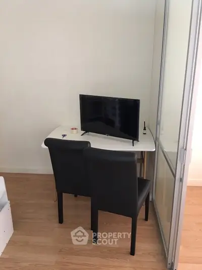 Compact study area with TV and chairs in modern apartment