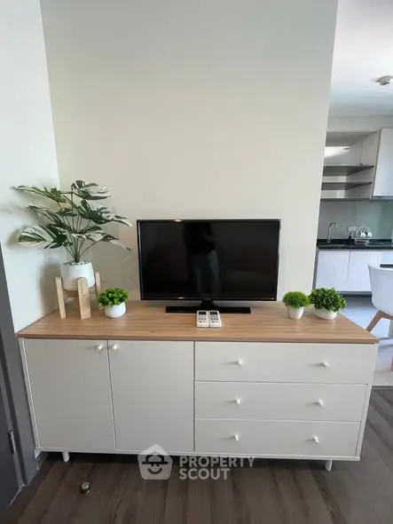 Modern living room with stylish TV stand and kitchen view