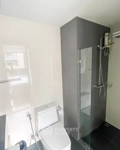 Modern bathroom with sleek shower and toilet in a contemporary apartment.