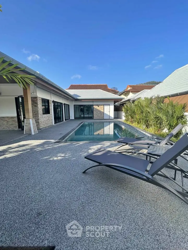 Luxurious modern villa with private pool and sun loungers in tropical setting