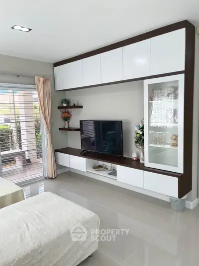 Modern living room with sleek cabinetry and large window for natural light.