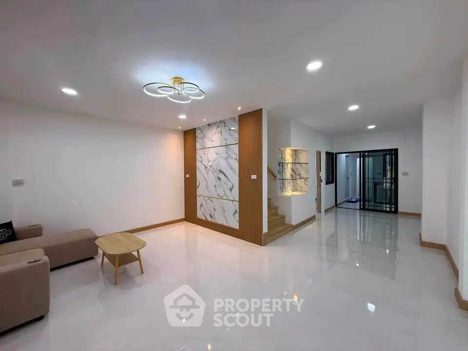 Spacious modern living room with elegant marble accent wall and stylish lighting