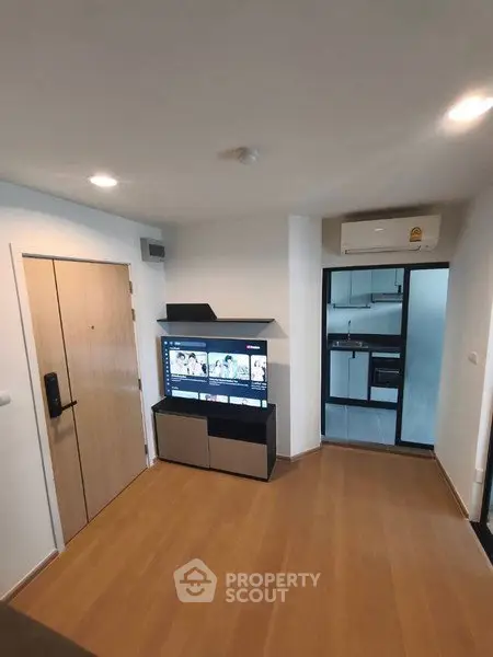 Modern living room with wooden flooring and sleek kitchen view
