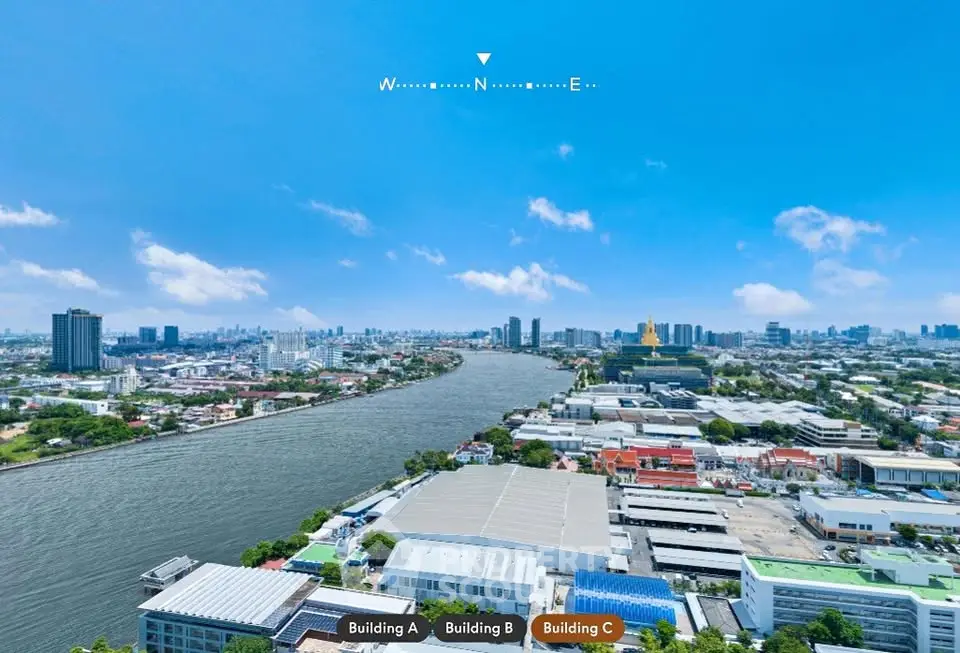 Stunning aerial view of cityscape with river and skyline under clear blue sky.