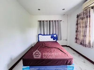 Spacious bedroom with modern bed and air conditioning, perfect for comfort and relaxation.