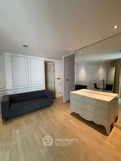 Spacious living room with elegant furniture and large mirror, perfect for modern living.