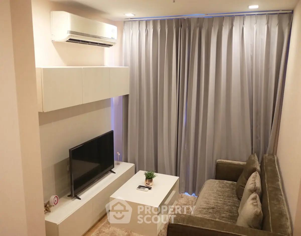 Cozy living room with modern furniture and air conditioning, perfect for relaxation.