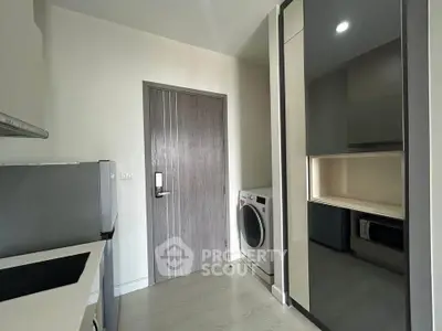 Modern kitchen with sleek appliances and washing machine in stylish apartment