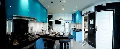 Modern kitchen with blue LED lighting, sleek black countertops, and high-end appliances, perfect for culinary enthusiasts.