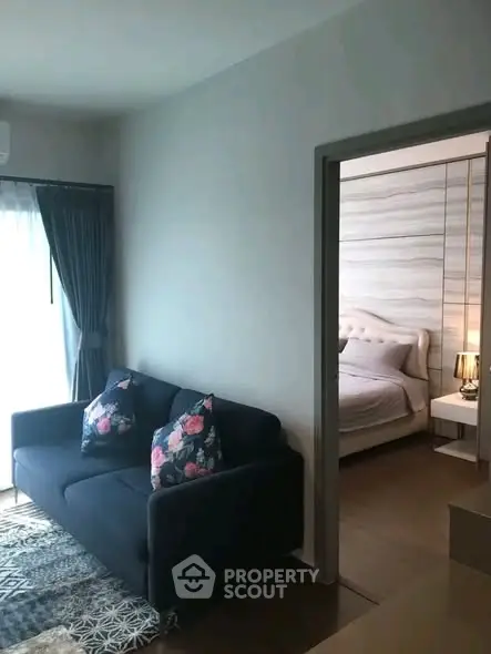 Cozy living room with a view into a stylish bedroom, featuring modern decor and natural light.