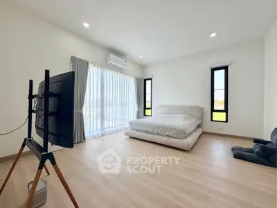 Spacious modern bedroom with large windows and natural light