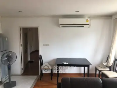 Cozy living area with air conditioning and dining set in modern apartment.