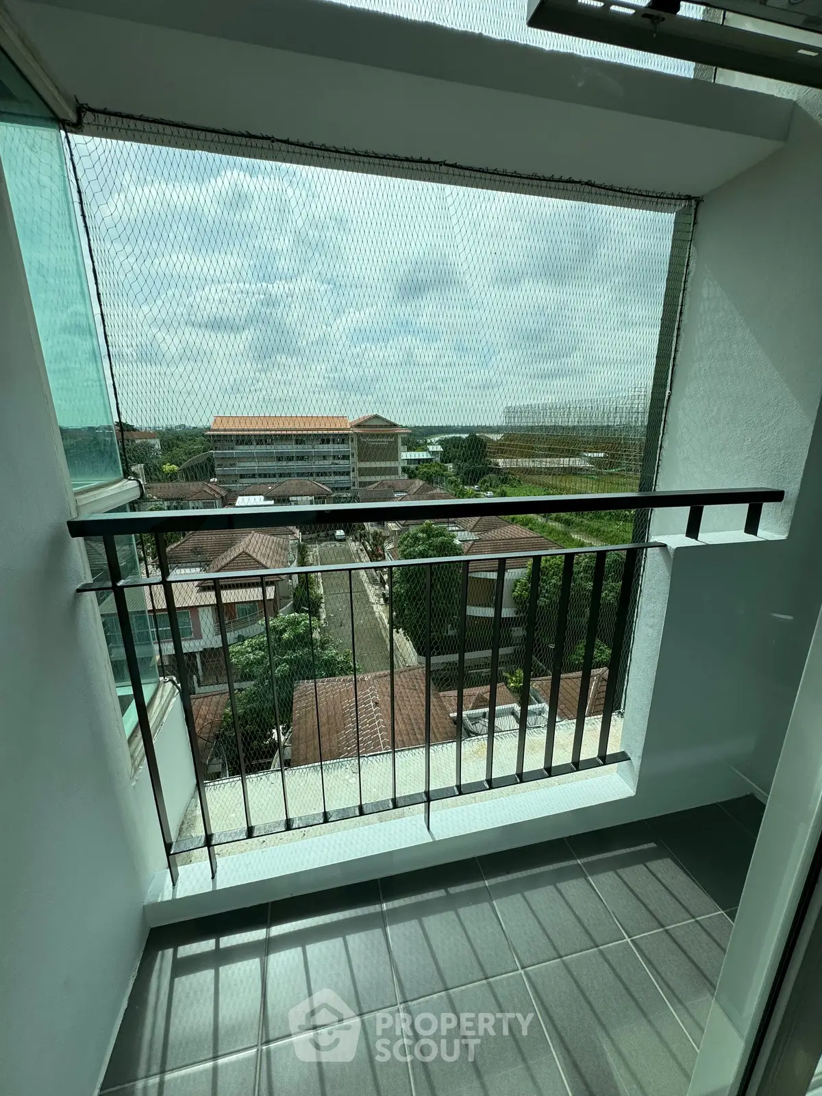 Charming balcony with safety netting and scenic view of neighborhood rooftops.