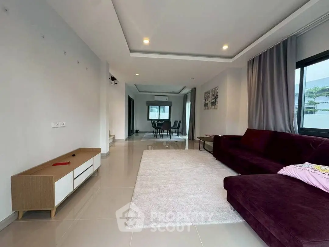 Spacious modern living room with elegant furniture and large windows for natural light.