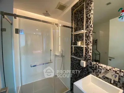 Modern bathroom with glass shower and mosaic tile accent wall